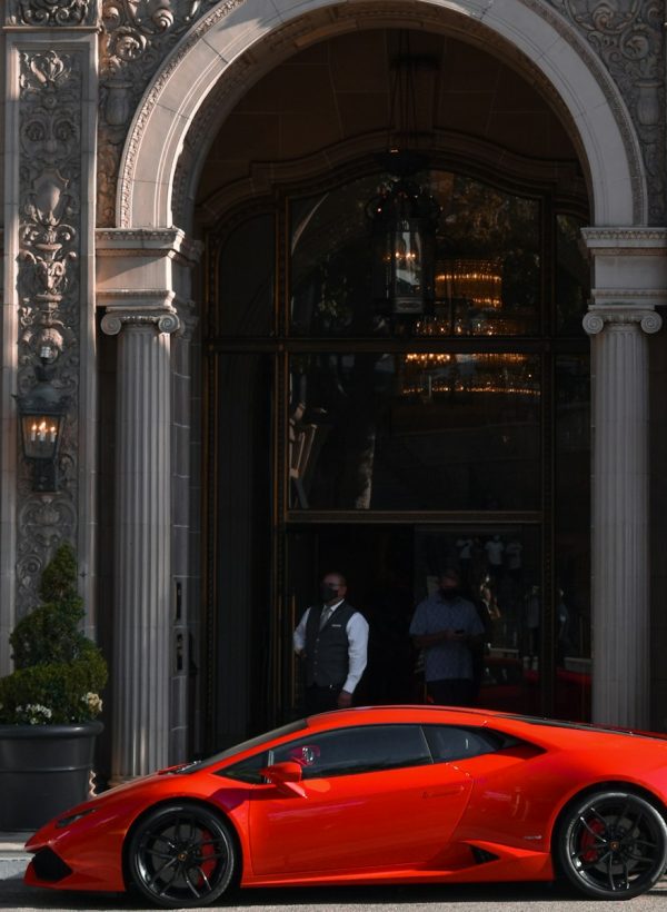 a red sports car parked in front of a building with columns